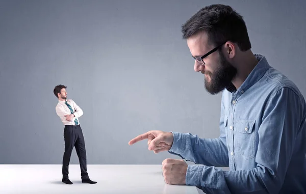 Joven hombre de negocios luchando con empresario en miniatura — Foto de Stock