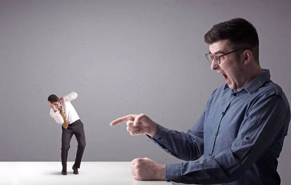 Young businessman fighting with miniature businessman — Stock Photo, Image