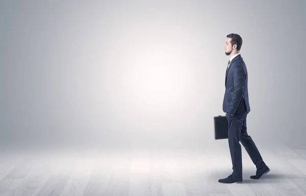 Empresario caminando frente a una pared vacía — Foto de Stock