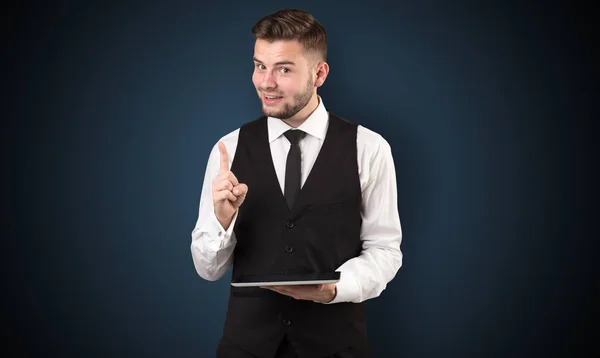 Empresario sosteniendo tableta con fondo oscuro — Foto de Stock