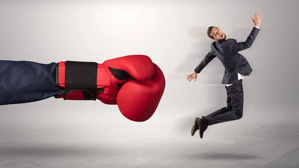 Giant hand gives a kick to a small businessman — Stock Photo, Image