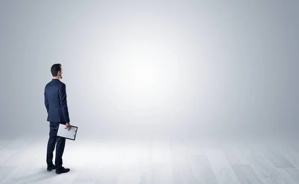 Man met object in zijn hand in een lege ruimte — Stockfoto