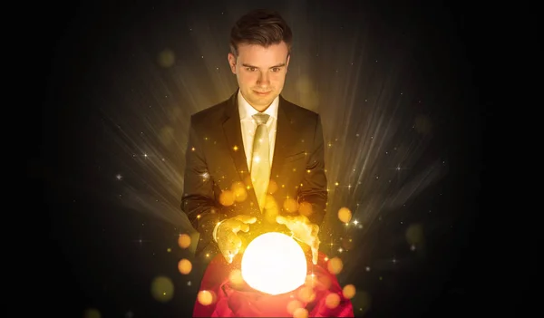 Businessman  sitting with sparkling magic ball — Stock Photo, Image