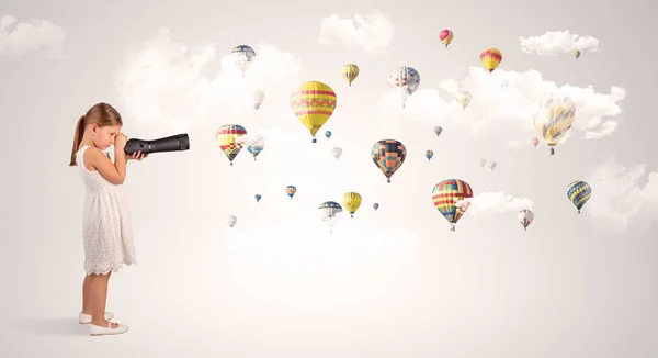 Kid looking through spyglass to air balloons — Stock Photo, Image