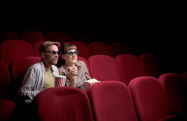 Jovem casal sentado no cinema vermelho — Fotografia de Stock