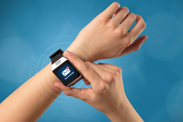 Ręka z zegarka smartwatch i niebieskie tło — Zdjęcie stockowe