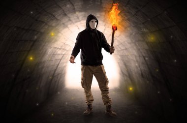 Karanlık bir tünelde flambeau yanma ile yürüyen adam