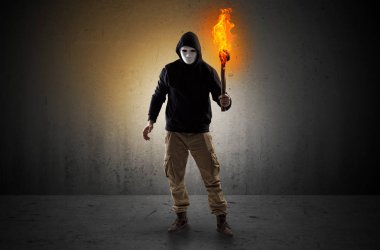 Boş bir alanda flambeau yanma ile yürüyen adam