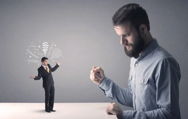 Young businessman fighting with miniature businessman — Stock Photo, Image