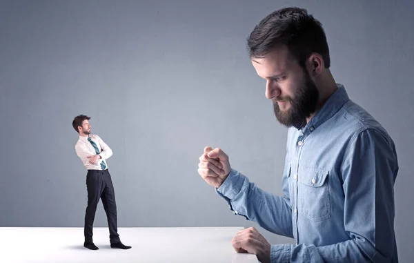 Young businessman fighting with miniature businessman — Stock Photo, Image