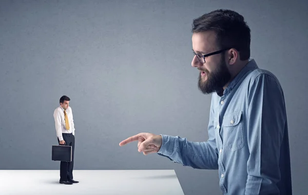 Joven hombre de negocios luchando con empresario en miniatura —  Fotos de Stock