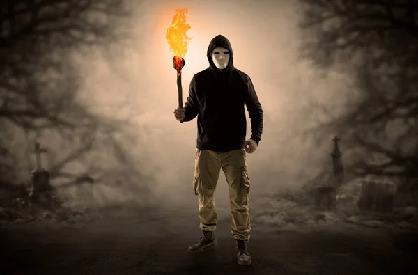 Homem saindo de um matagal com flambeau ardente — Fotografia de Stock