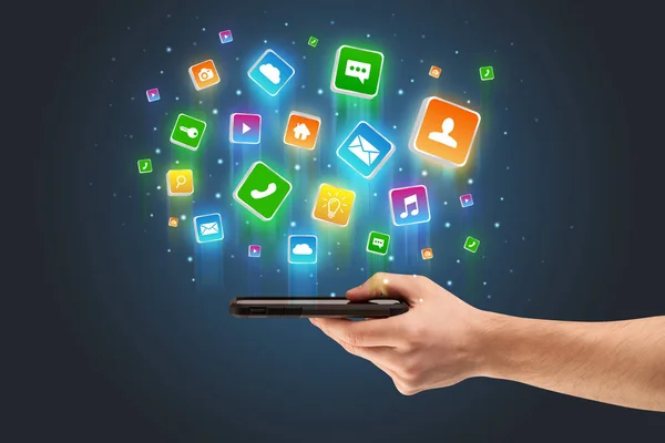 Main utilisant le téléphone avec des icônes d'application volant autour — Photo