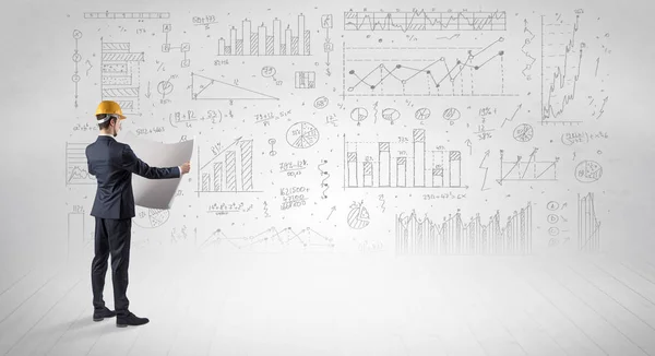 Engenheiro segurando um plano e de pé com gráficos, gráficos e relatórios em segundo plano — Fotografia de Stock