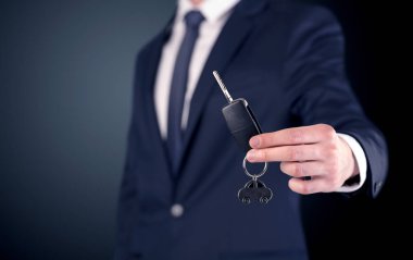 Genç işadamı el tuşları ile boş koyu arka plan üzerinde