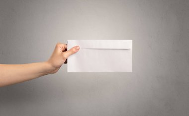 Zarf boş duvar arka plan ile tutan el