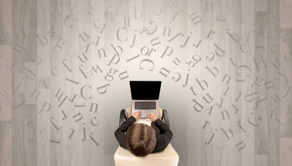 Bir sandalyede dizüstü bilgisayar kullanan kadın harflerle — Stok fotoğraf