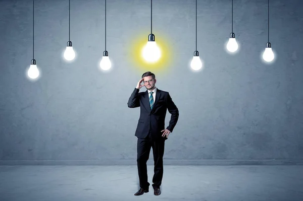 Empresário de pé sem inspiração com lâmpadas acima — Fotografia de Stock