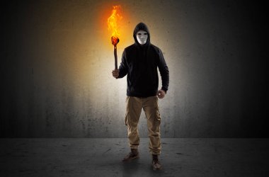 Boş bir alanda flambeau yanma ile yürüyen adam