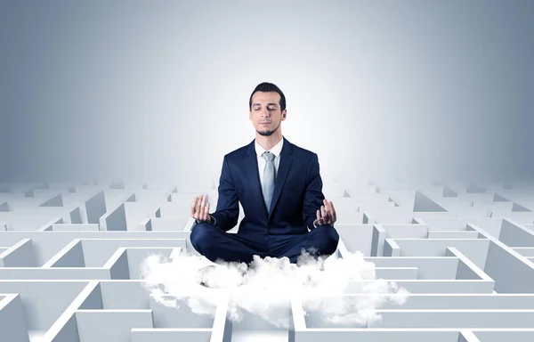 Affärsman mediterar på ett moln med labyrint koncept — Stockfoto