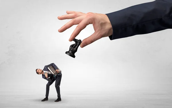 Grande mão com o xadrez para baixo pequeno conceito fraco homem de negócios — Fotografia de Stock