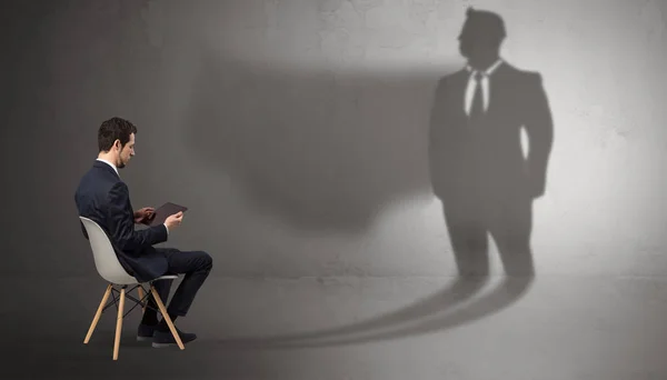 Businessman staying and offering stuffs to a huge bull shadow — Stock Photo, Image