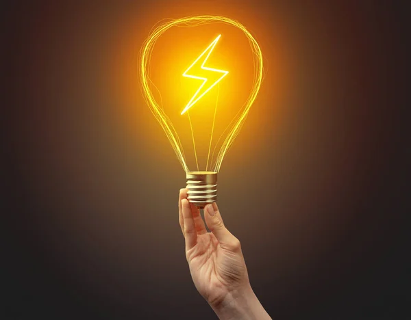 Hand holding light bulb on dark background — Stock Photo, Image