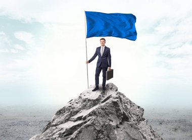 İşadamı üst tarafındaki bir bayrak tutan dağ