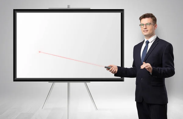 Businessman with laser pointer and copyspace white wall — Stock Photo, Image