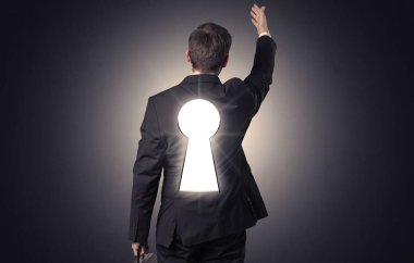 Sırtında siyah anahtar deliği ile ayakta adam