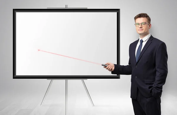 Businessman with laser pointer and copyspace white wall — Stock Photo, Image