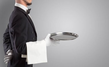Beyaz eldiven ve çelik tepsi ile hizmet veren garson
