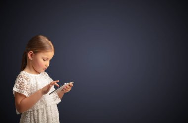 Tablet ile koyu arka plan kullanarak sevimli küçük kız