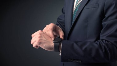 Smartwatch giyen takım elbiseli adam.