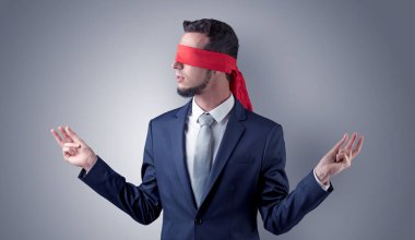 Kapalı göz işadamı bir duvarın önünde