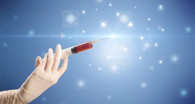 Kadın doktor elinde şırınga tutuyor.