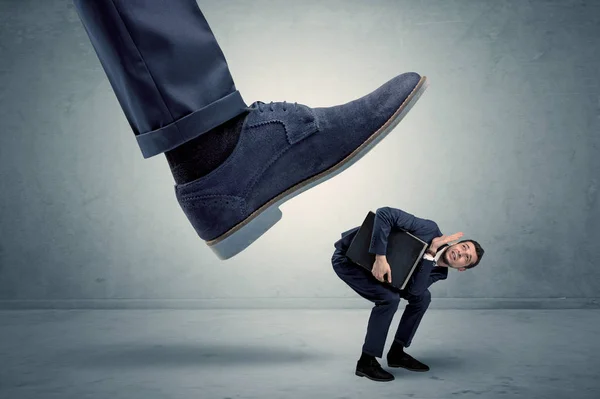 Anställd får trampas av stora sko — Stockfoto