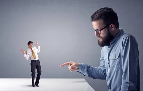 Joven hombre de negocios luchando con empresario en miniatura — Foto de Stock