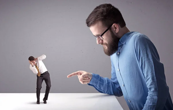 Joven hombre de negocios luchando con empresario en miniatura —  Fotos de Stock