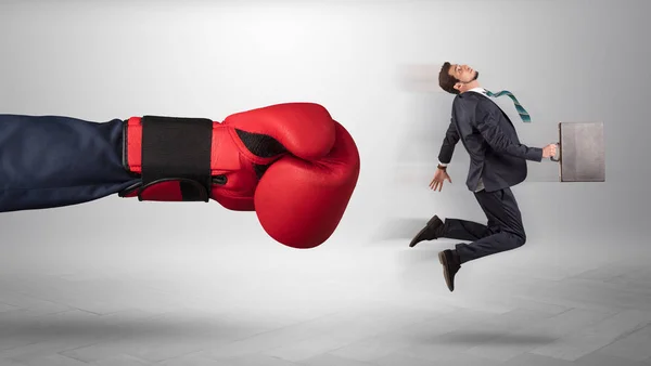 Mão gigante dá um chute a um pequeno empresário — Fotografia de Stock