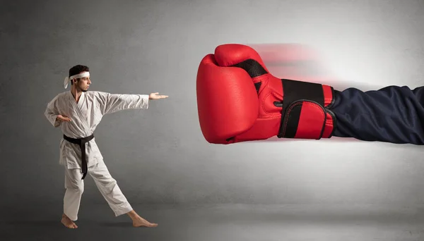 Маленький человек сражается в большой красной боксерской перчатке — стоковое фото