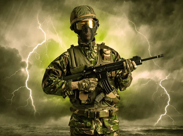 Ozbrojený voják stojící v temné počasí — Stock fotografie