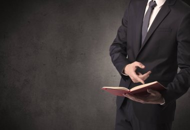 Elinde kitap tutan bir işadamı.