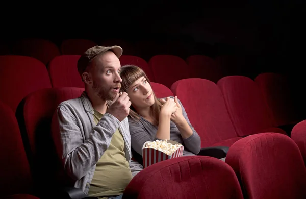 Jeune couple assis au cinéma rouge — Photo