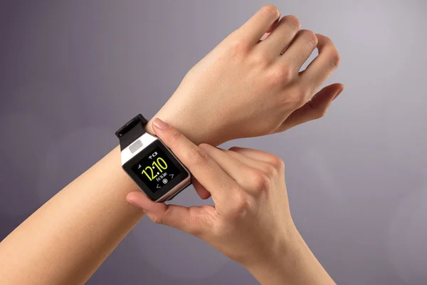 Kvinnlig hand bär och trycka på smartwatch — Stockfoto