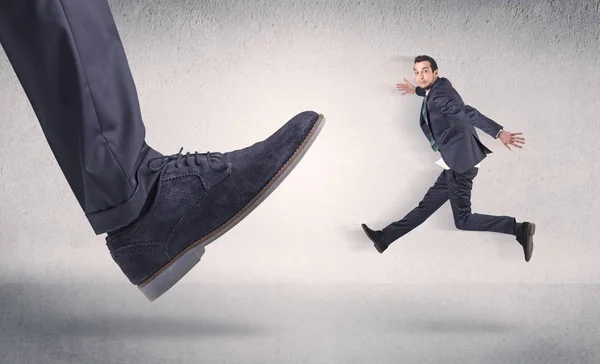 大きな靴に蹴ら小さいビジネスマン — ストック写真