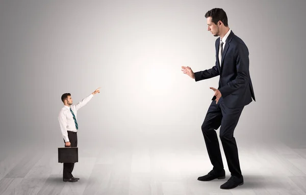 Pequeño empresario señalando a un hombre de negocios gigante — Foto de Stock