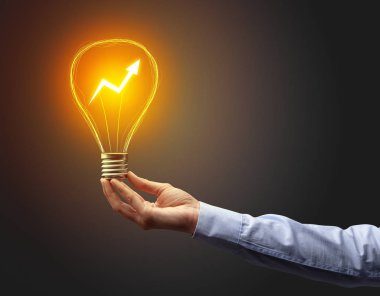 Koyu arkaplanda el ele tutuşan ampul