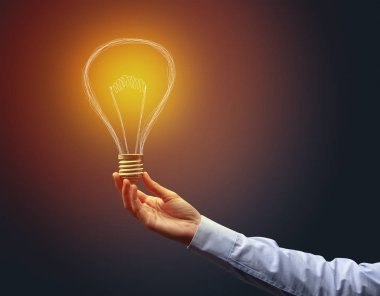 Koyu arkaplanda el ele tutuşan ampul