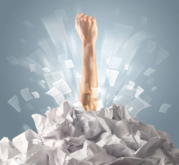 Hand coming out from paper pile — Stock Photo, Image